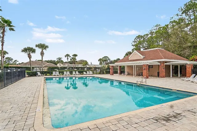 a view of a house with pool and sitting area