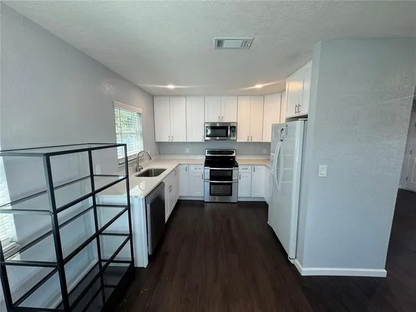 a kitchen with a refrigerator a sink and cabinets