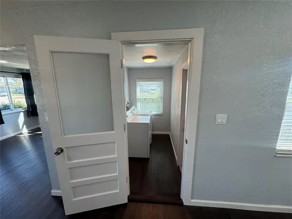 a view of a hallway with wooden floor and stairs