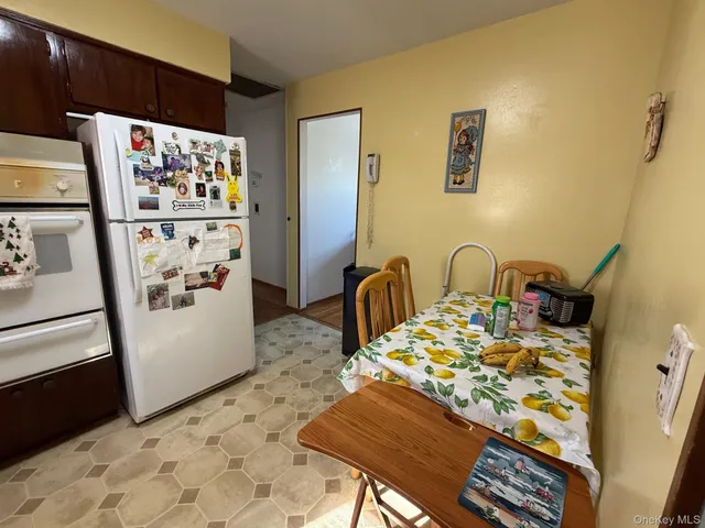 a view of a kitchen area with furniture and refrigerator