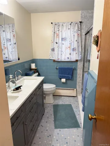 a bathroom with a granite countertop sink a mirror and a toilet