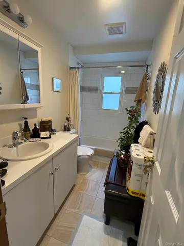 a bathroom with a sink and mirror with bathtub