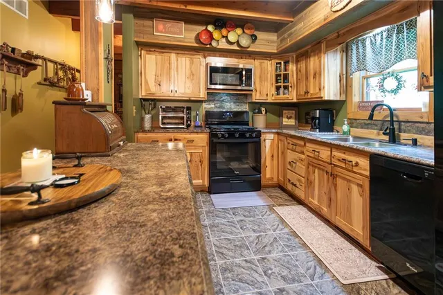 a kitchen with stainless steel appliances granite countertop a stove sink and cabinets