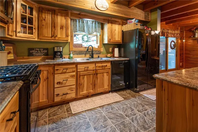 a kitchen with stainless steel appliances granite countertop a refrigerator a stove and a sink