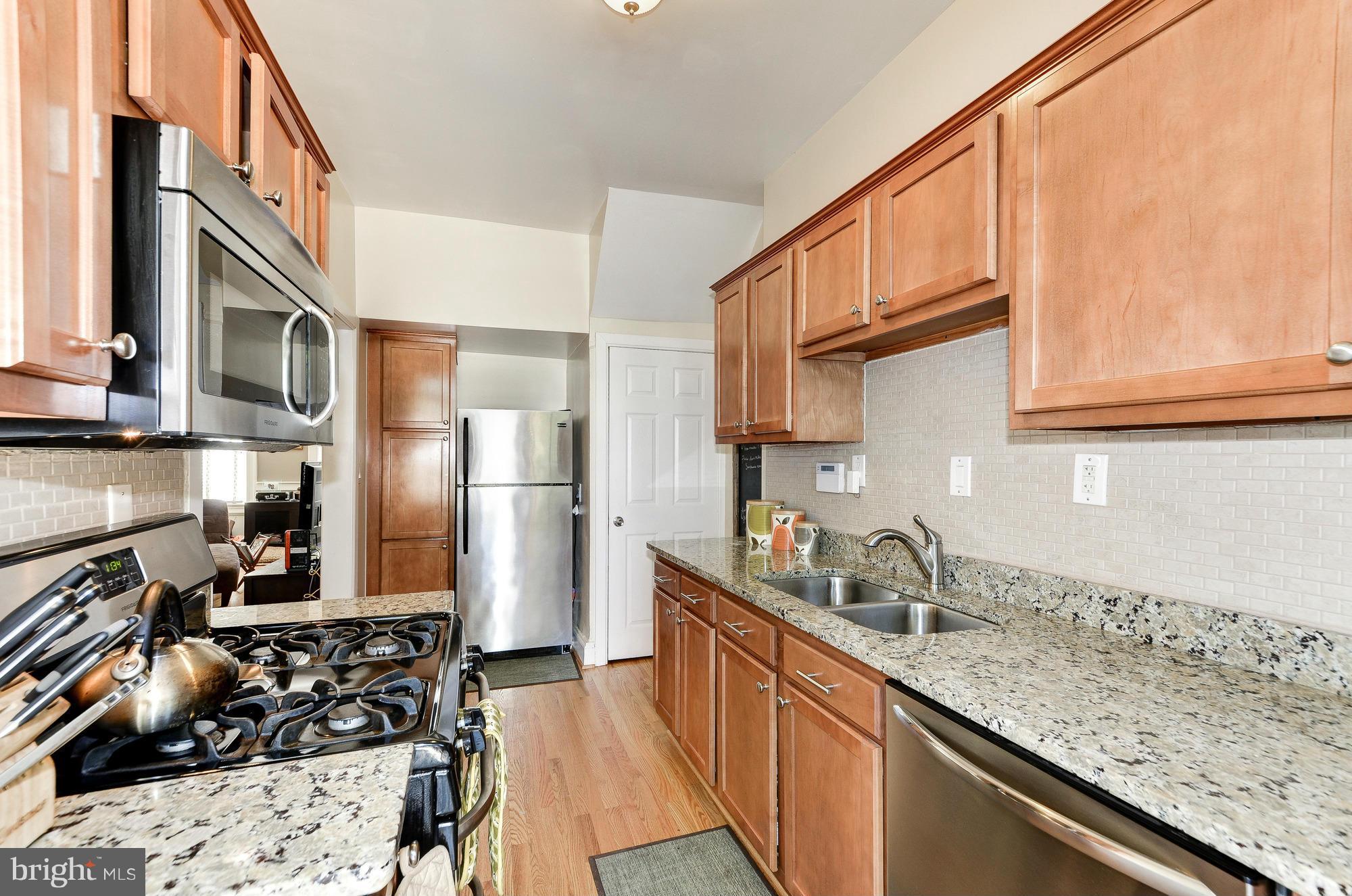 809 Jefferson Street Northwest Washington, DC 20011 - Photo 12 of 26 a kitchen with stainless steel appliances granite countertop a sink stove refrigerator and cabinets