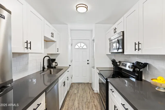 a kitchen with a sink stove and cabinets