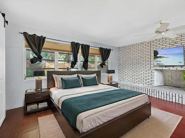 a bedroom with a bed wooden floor and window