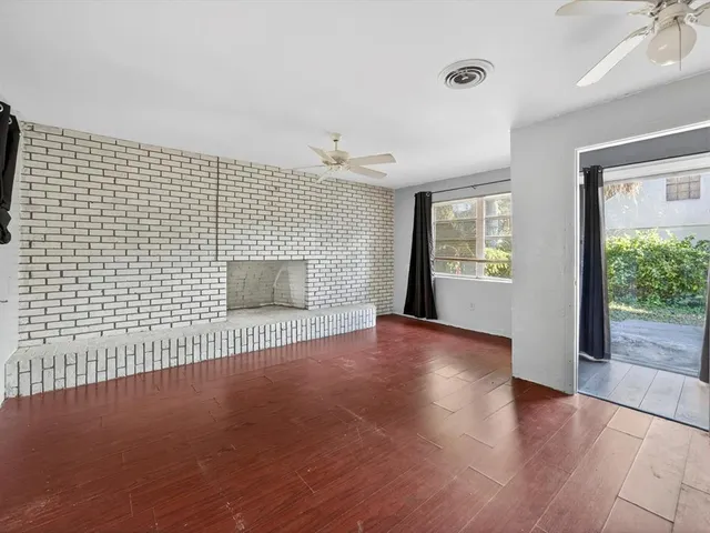 a view of a livingroom with wooden floor and a ceiling fan