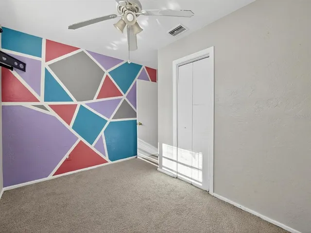 a room that has a ceiling fan and a floor