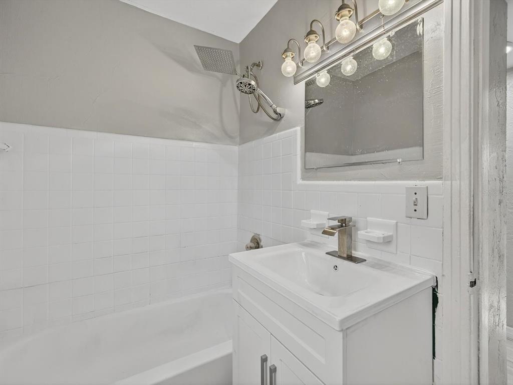 1068 Peter Road Daytona Beach, FL 32114 - Photo 19 of 37 a bathroom with a sink a mirror and a shower