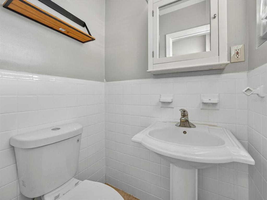 1068 Peter Road Daytona Beach, FL 32114 - Photo 22 of 37 a bathroom with a sink a toilet and mirror
