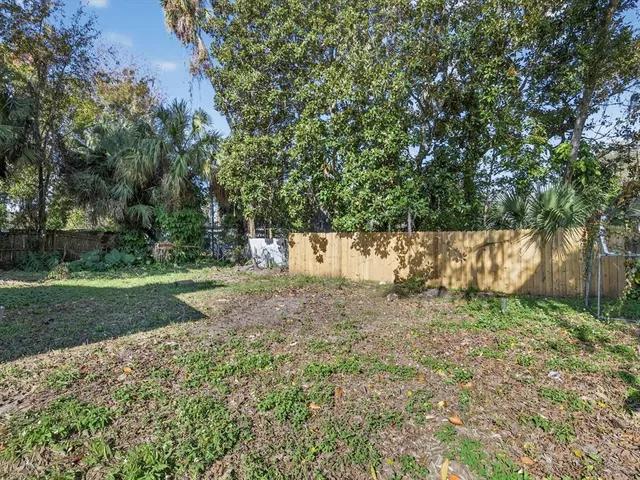 a view of a yard with plants and trees
