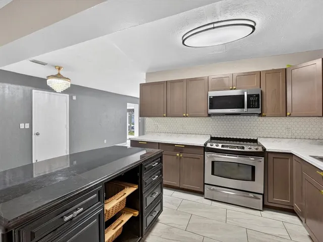 a kitchen with stainless steel appliances granite countertop a stove and a microwave