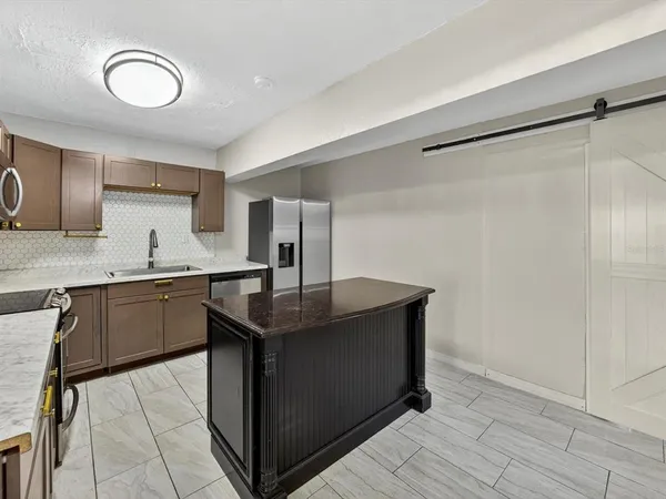 a kitchen with stainless steel appliances granite countertop a sink refrigerator and cabinets