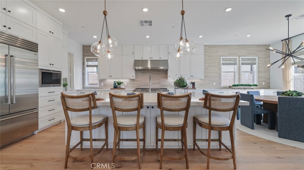 21381 Cloud Ridge Yorba Linda, CA 92887 - Photo 2 of 38 a kitchen with stainless steel appliances kitchen island granite countertop a stove a sink a dining table and chairs