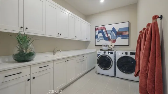 a utility room with sink dryer and washer