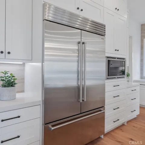 a kitchen with white cabinets and a refrigerator