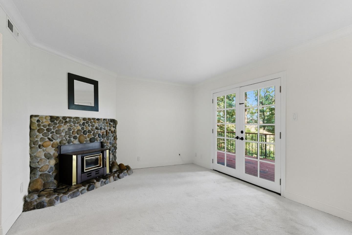 23489 Hutchinson Road Los Gatos, CA 95033 - Photo 16 of 46 a view of an empty room with a fireplace and a window
