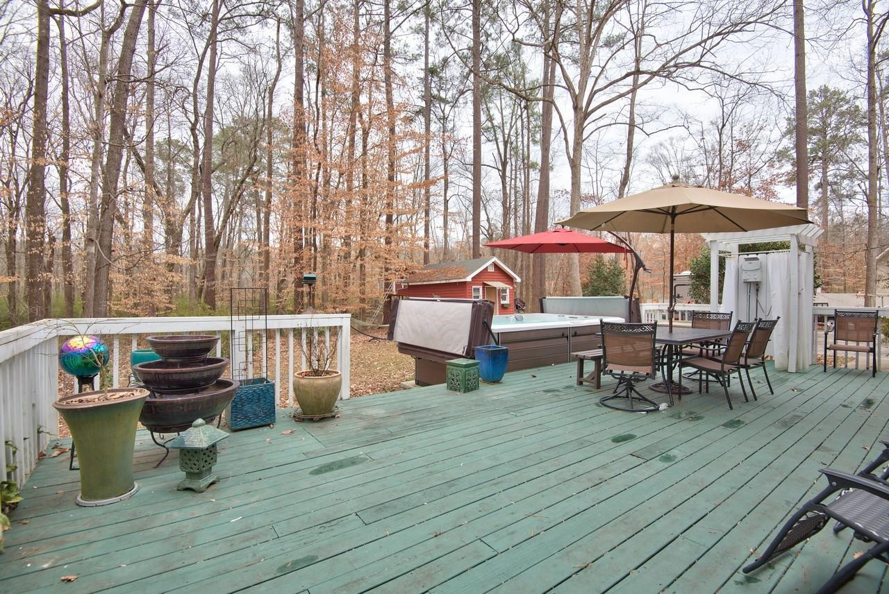 3563 Hamstead Court Durham, NC 27707 - Photo 34 of 37 a view of a patio with table and chairs under an umbrella with wooden floor
