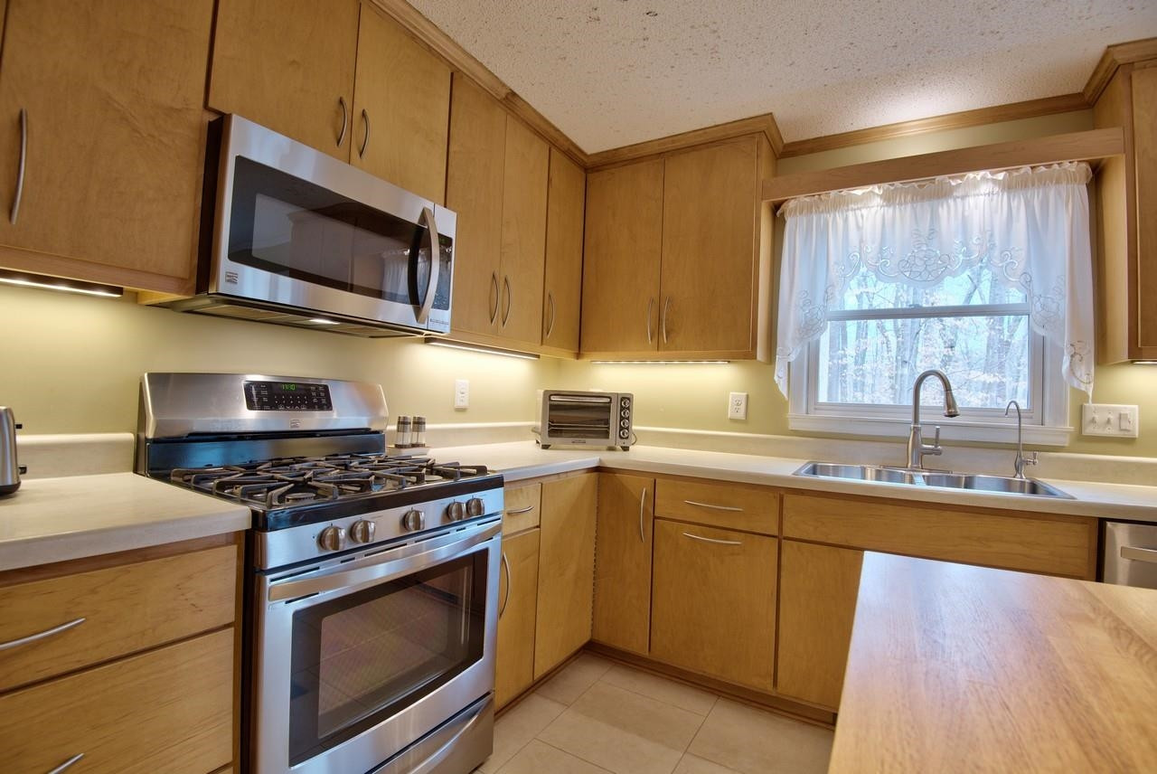 3563 Hamstead Court Durham, NC 27707 - Photo 7 of 37 a kitchen with stainless steel appliances a stove microwave and sink