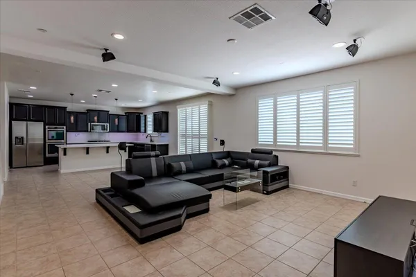 a living room with stainless steel appliances kitchen island granite countertop furniture and a large window