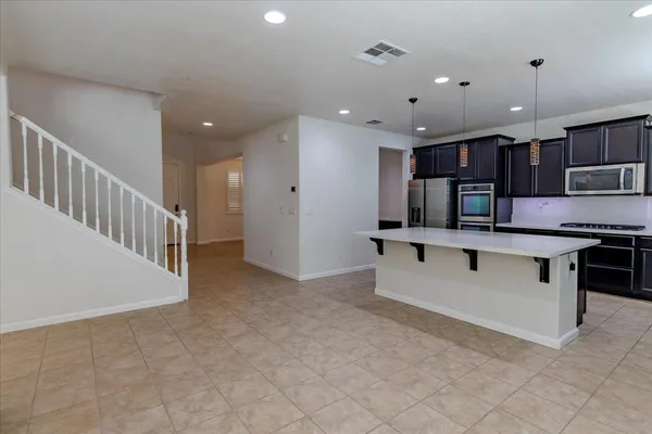 a view of kitchen with kitchen island and stainless steel appliances