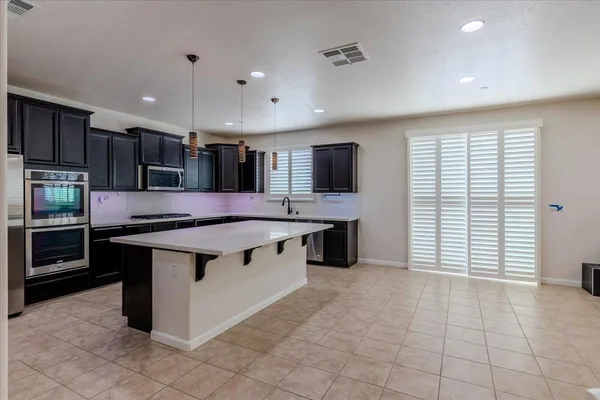 a large kitchen with kitchen island a sink counter space and cabinets