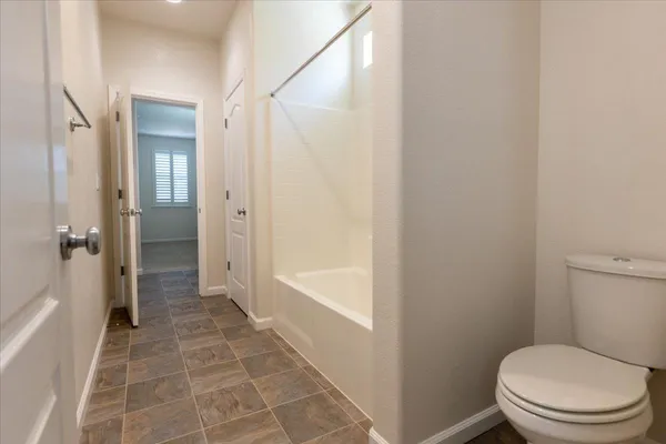 a bathroom with a granite countertop toilet a sink and shower