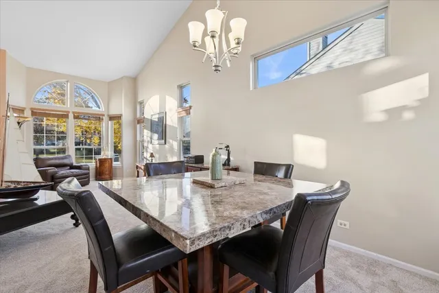 a dining room with furniture a chandelier and wooden floor