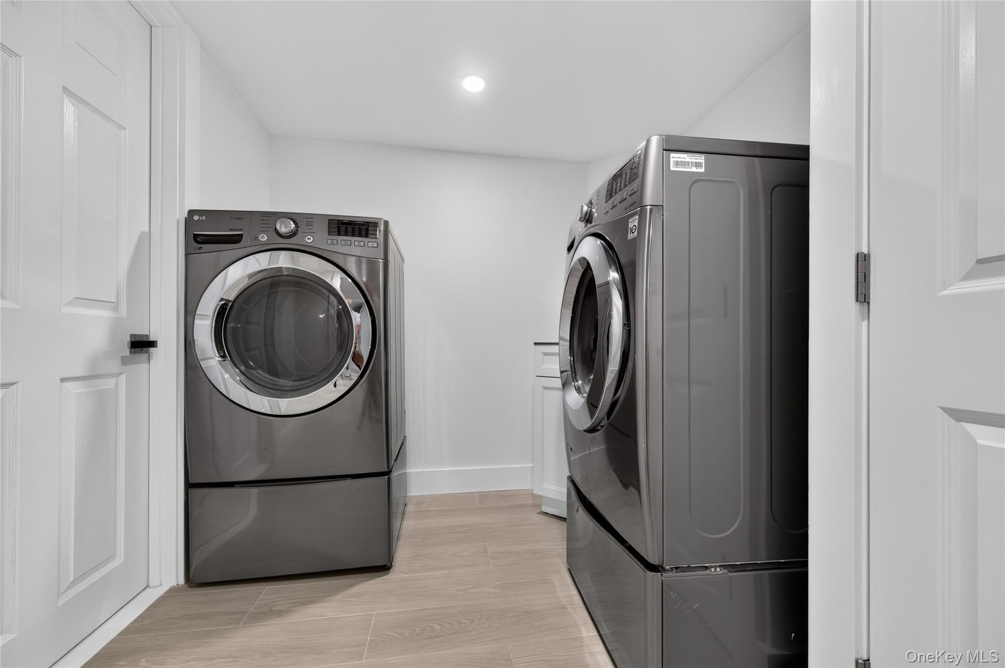 11 Sunbeam Road Syosset, NY 11791 - Photo 20 of 28 Dedicated laundry area featuring a front-loading washer and dryer set