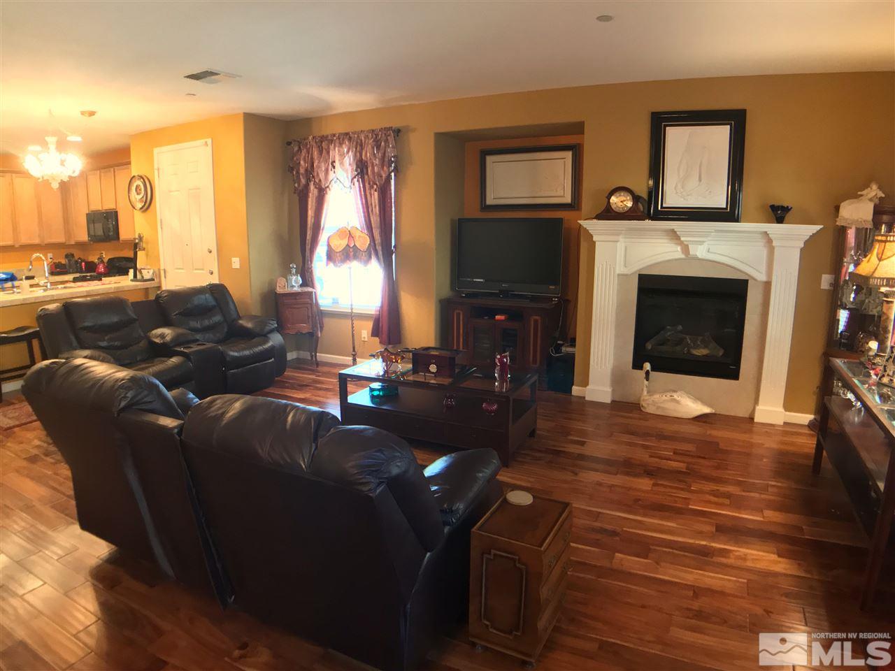 1924 Wind Ranch Road, Unit A Reno, NV 89521 - Photo 3 of 17 a living room with furniture a large window and a fireplace
