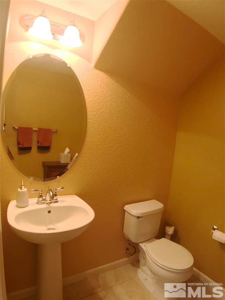 1924 Wind Ranch Road, Unit A Reno, NV 89521 - Photo 8 of 17 a bathroom with a sink mirror and toilet