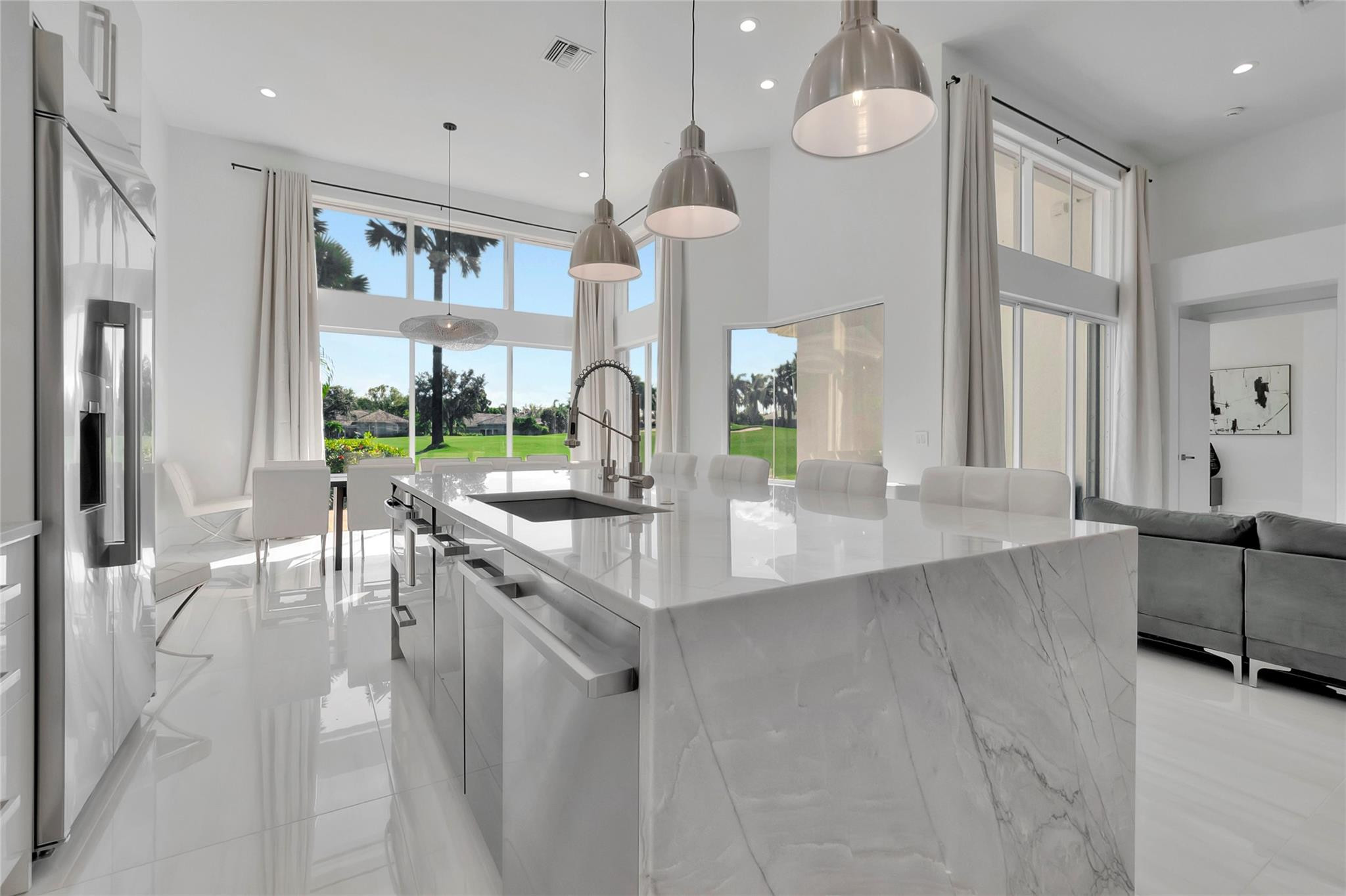 a large kitchen with granite countertop a large counter top a sink and stainless steel appliances