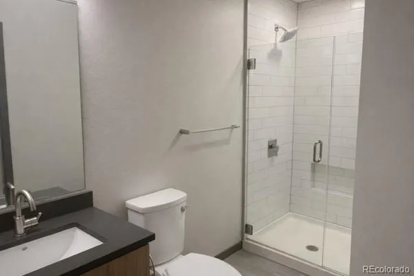a bathroom with a shower a toilet and sink
