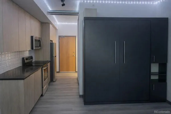 a kitchen with stainless steel appliances granite countertop a refrigerator and a stove