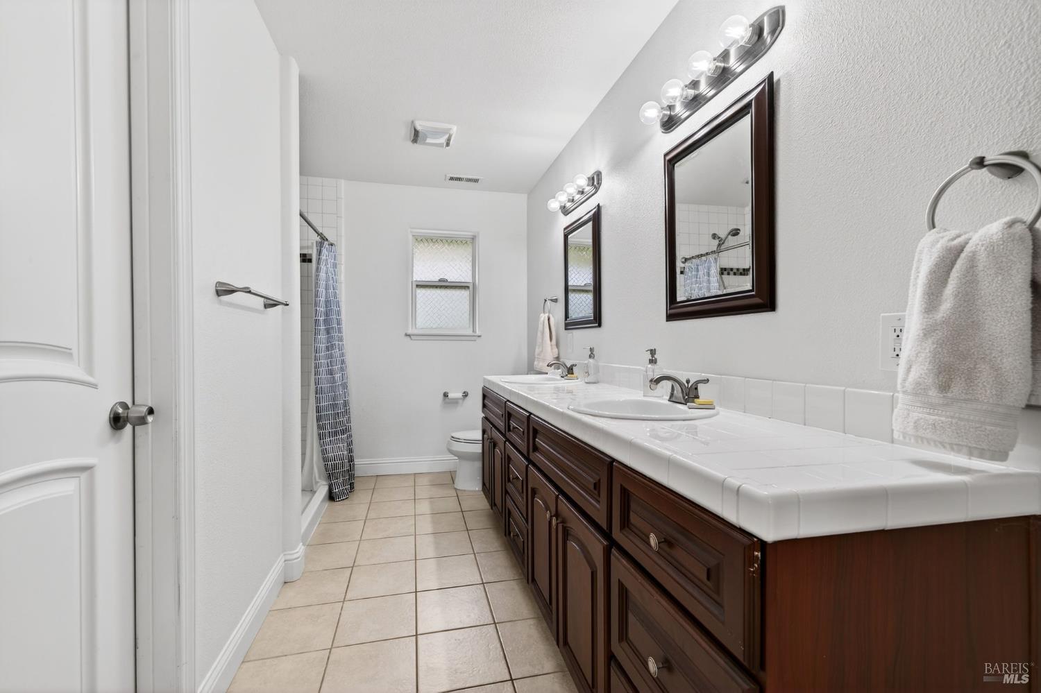 17437 Greenridge Road Hidden Valley Lake, CA 95467 - Photo 39 of 54 a bathroom with a double vanity sink mirror and