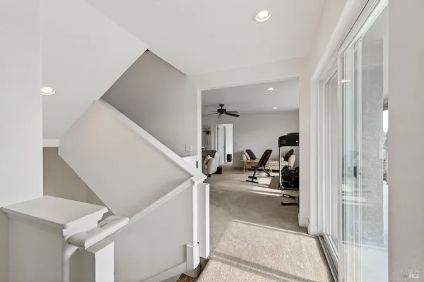 a view of a living room with white walls and stairs