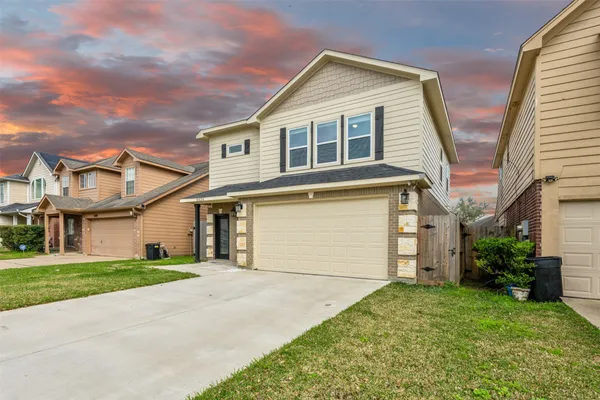 a front view of a house with a garden and garage
