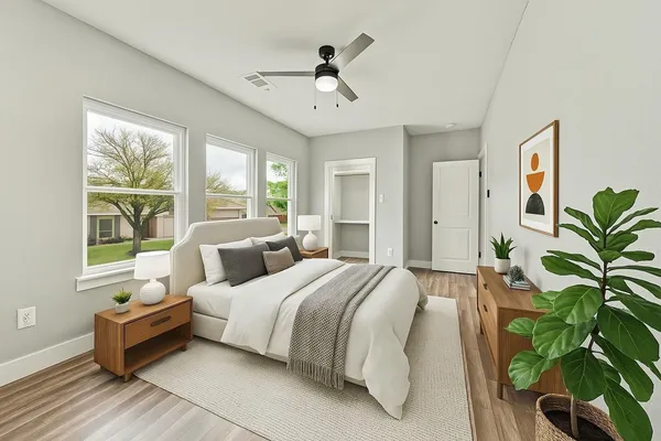 a view of an empty room with a window and wooden floor