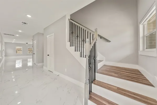 a view of staircase with white walls and windows