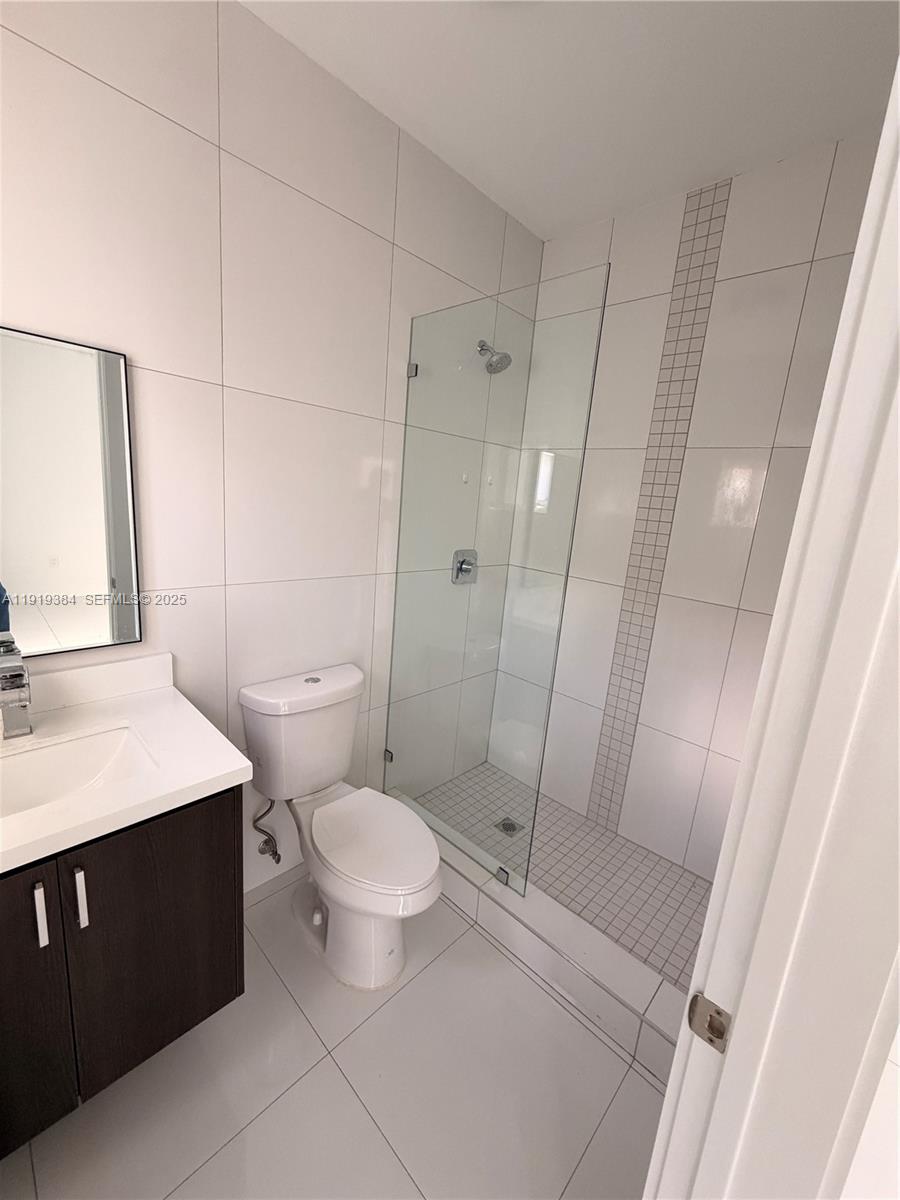 17334 Southwest 303rd Street Homestead, FL 33030 - Photo 16 of 34 a bathroom with a sink a toilet a mirror and shower