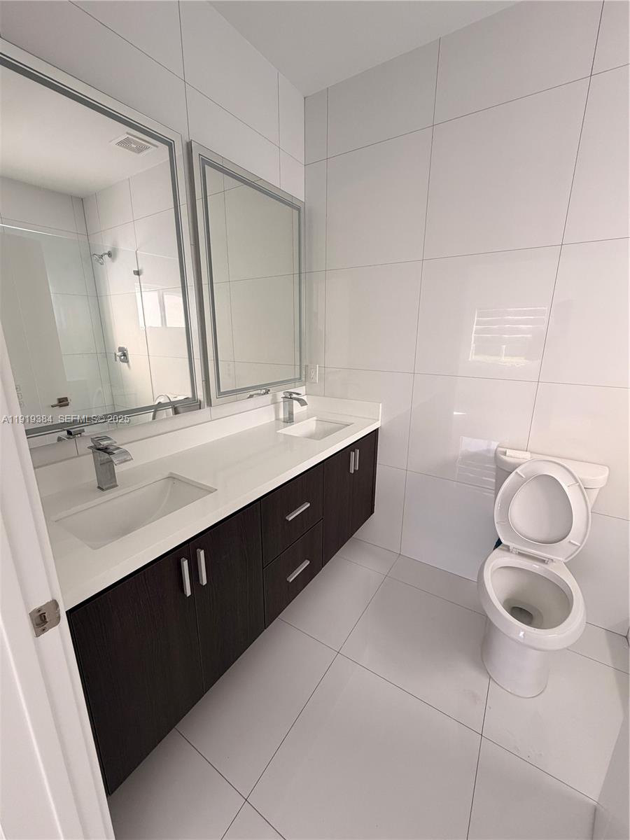 17334 Southwest 303rd Street Homestead, FL 33030 - Photo 22 of 34 a spacious bathroom with a double vanity sink toilet and a mirror