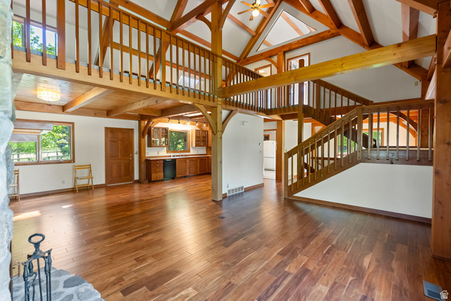 435 Canyon Road Millville, UT 84326 - Photo 11 of 113 Vaulted ceilings with exposed wood beams, wood-finish flooring, and a stone fireplace surround