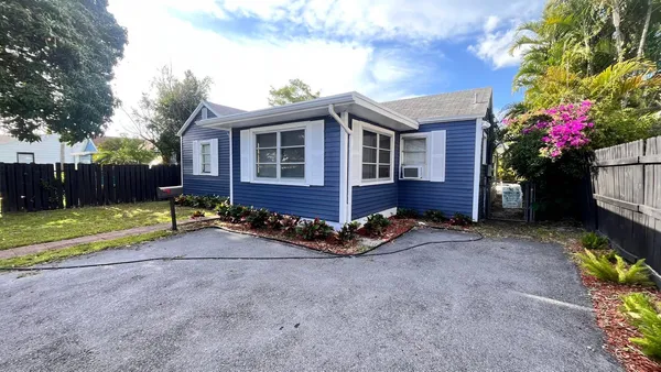 a view of a house with a yard and tree s