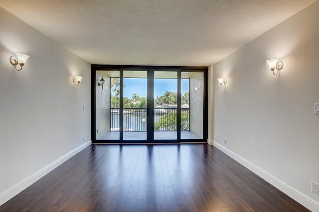 a view of a big room with wooden floor and kitchen view