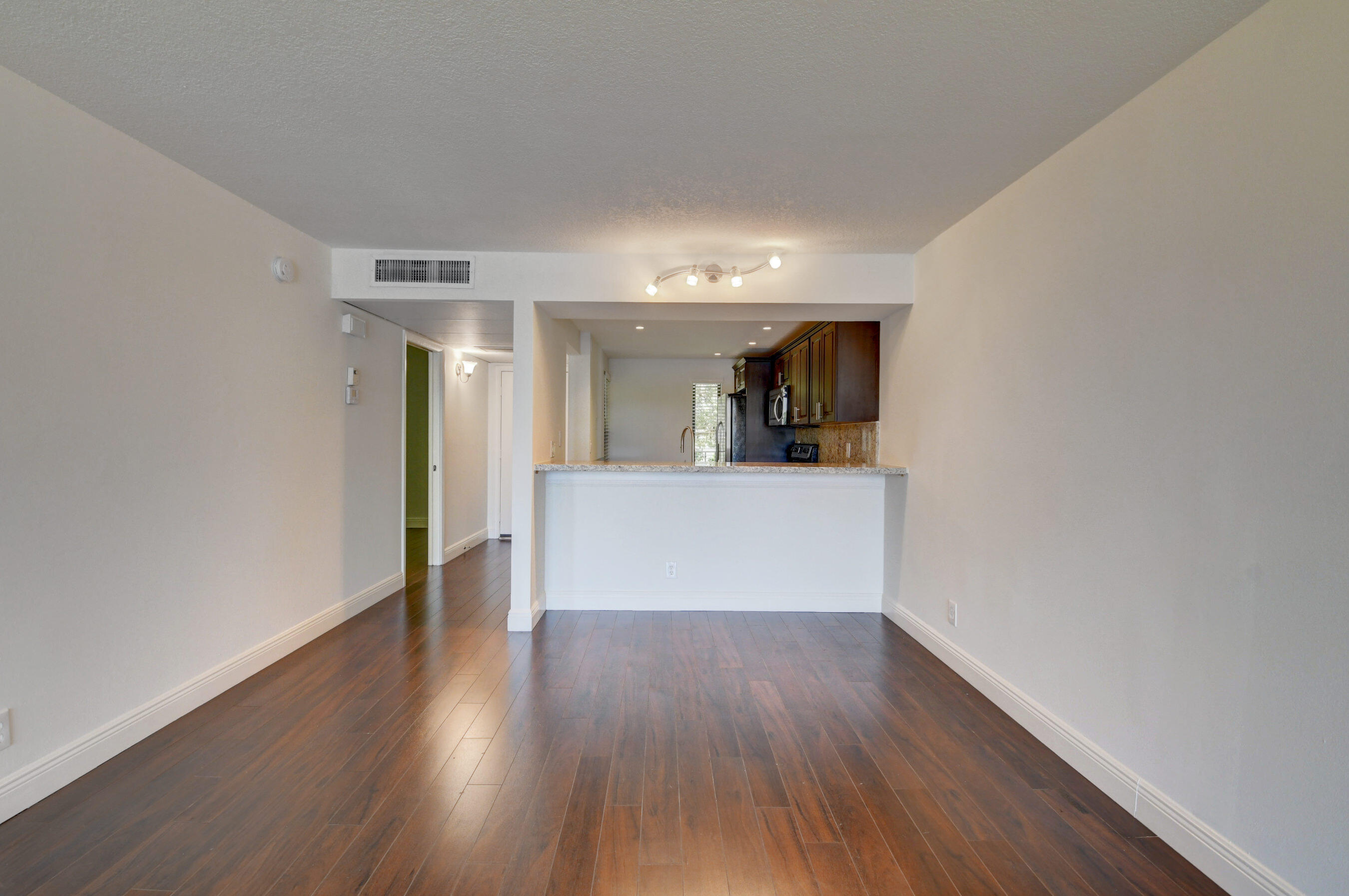 18 Royal Palm Way, Unit 202 Boca Raton, FL 33432 - Photo 12 of 51 a view of a big room with wooden floor and kitchen view