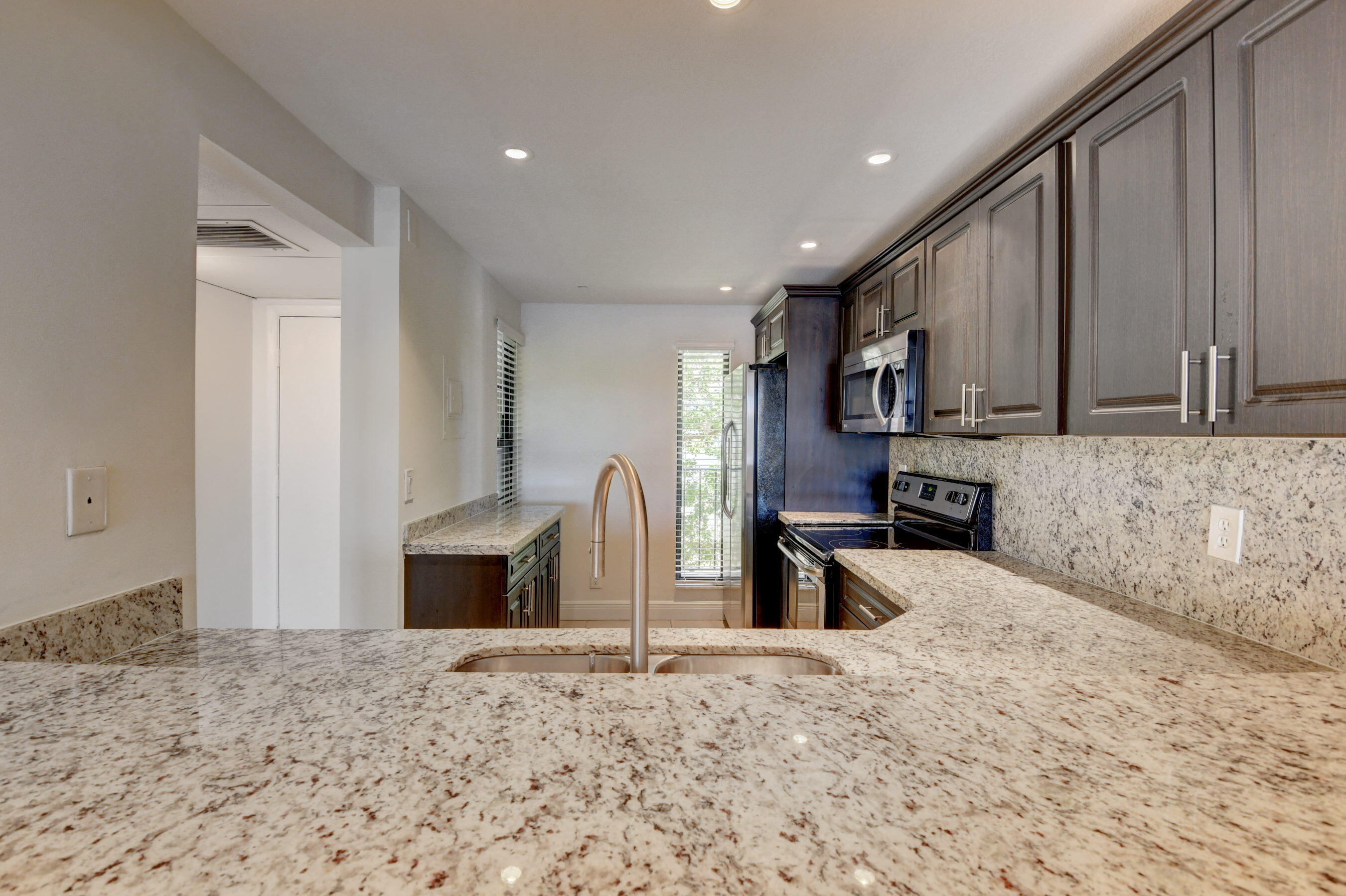 18 Royal Palm Way, Unit 202 Boca Raton, FL 33432 - Photo 13 of 51 a kitchen with stainless steel appliances granite countertop a refrigerator sink and stove