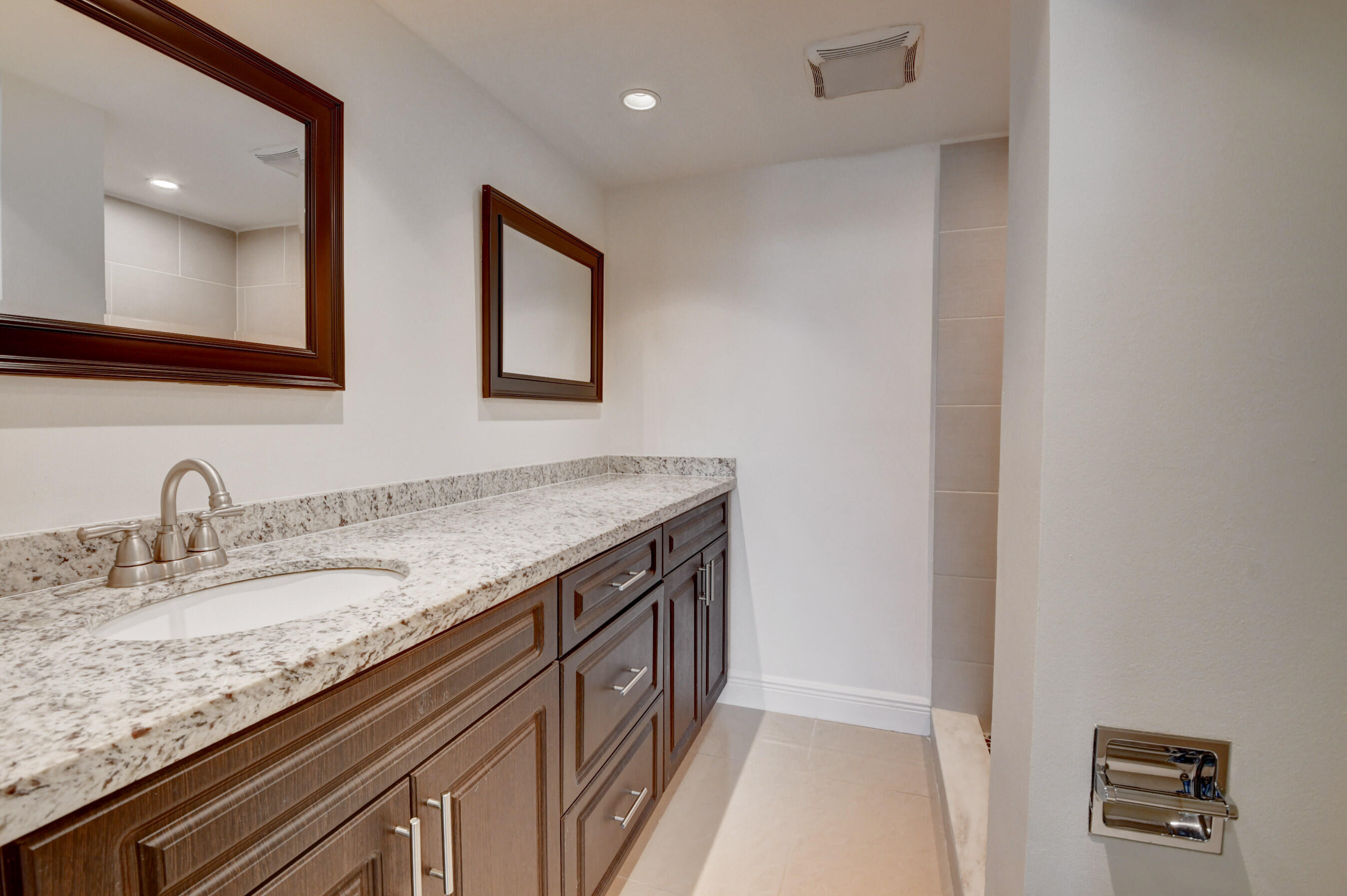18 Royal Palm Way, Unit 202 Boca Raton, FL 33432 - Photo 22 of 51 a bathroom with a granite countertop sink and a mirror