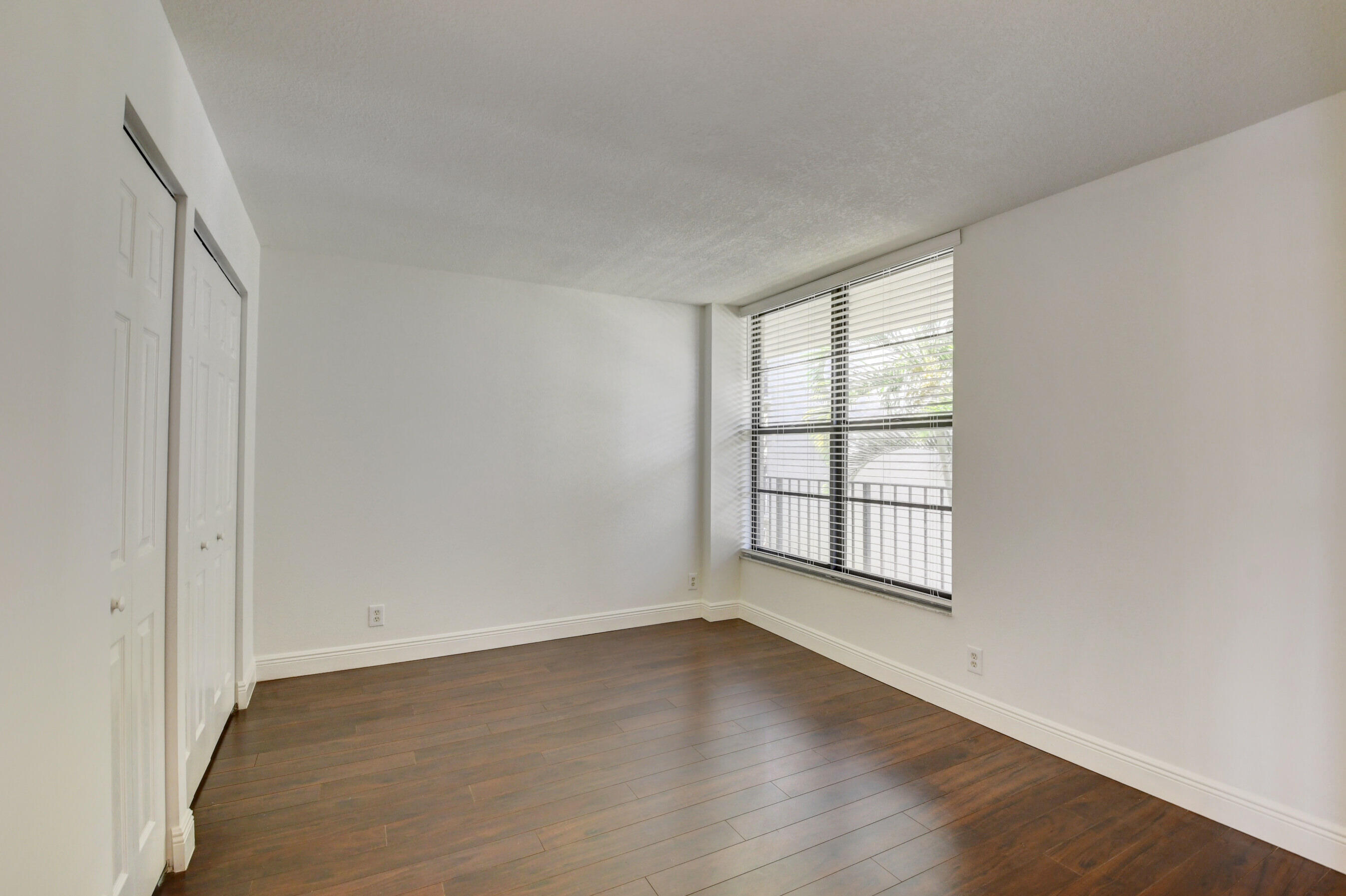 18 Royal Palm Way, Unit 202 Boca Raton, FL 33432 - Photo 25 of 51 an empty room with wooden floor and windows
