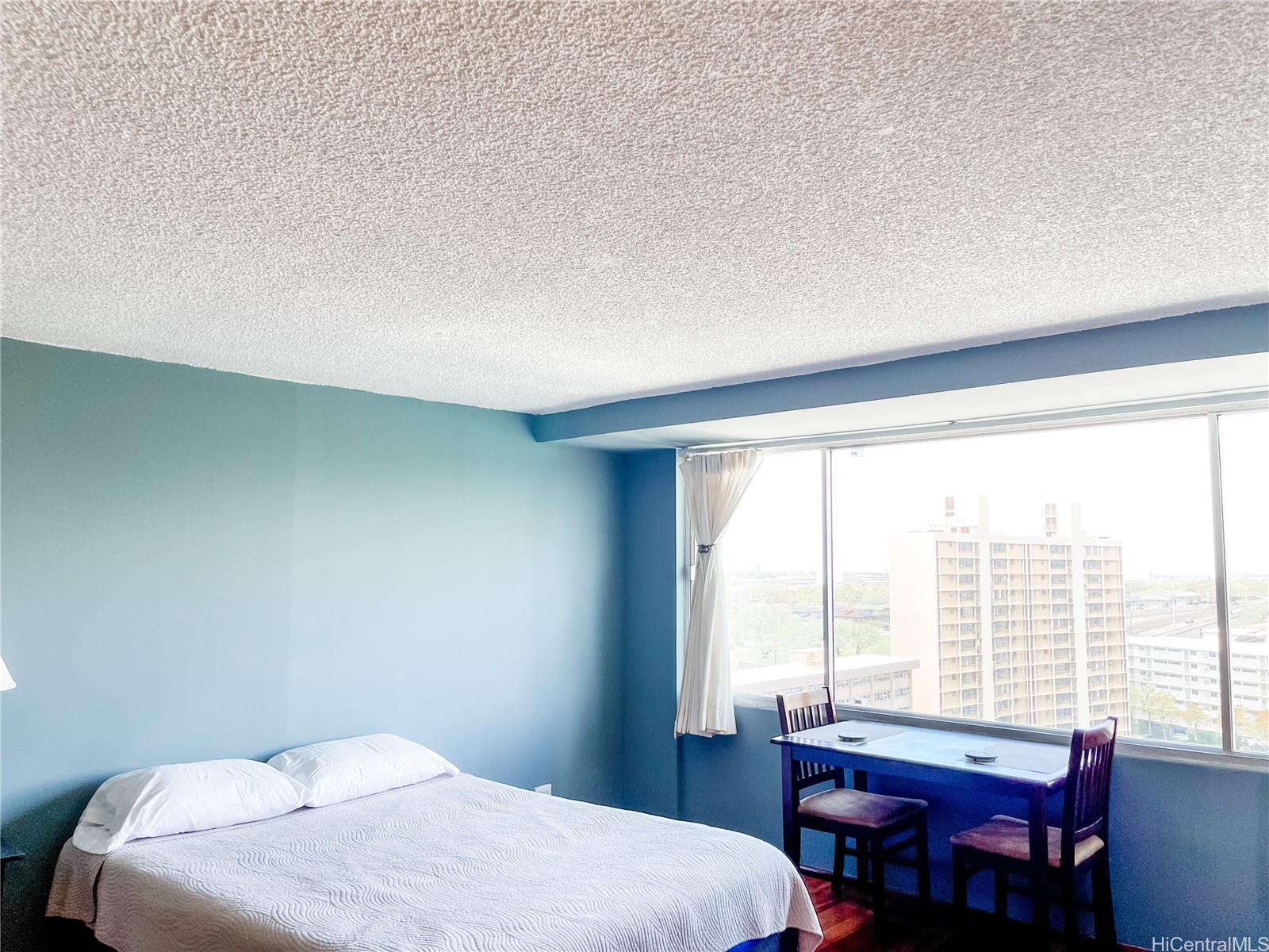 2888 Ala Ilima Street, Unit 1606 Honolulu, HI 96818 - Photo 1 of 1 a bedroom with a bed and a table